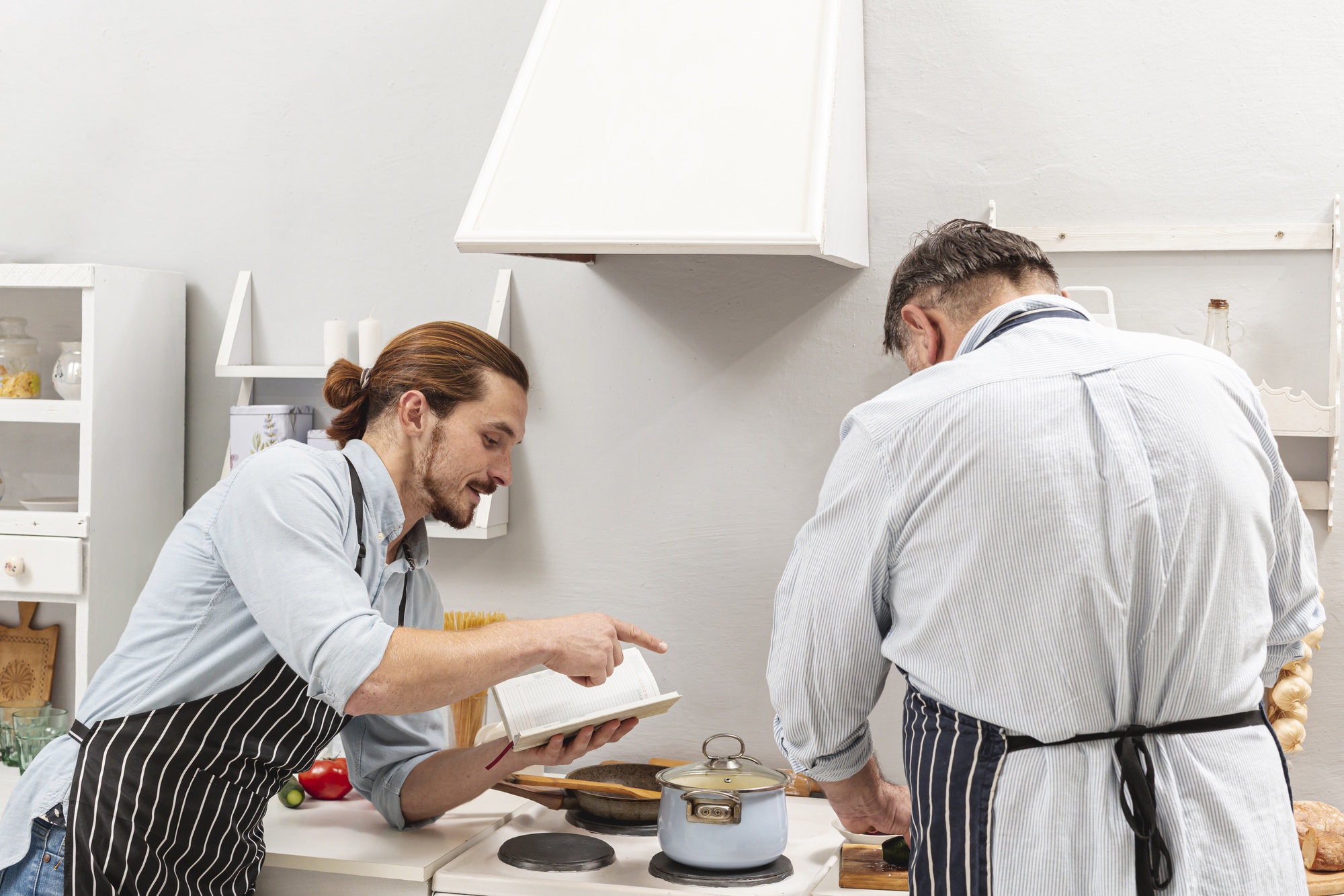 Two chefs discussing plating near stove